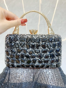 Detail of evening clutch featuring luxury rhinestones, black gems and gold bamboo handle