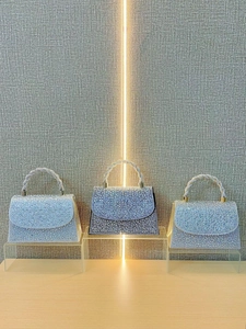 Elegant rhinestone evening bags in silver, black and blue with woven handles on stands