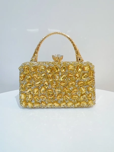 Detail of gold evening clutch featuring sparkling rhinestones and a crystal clasp