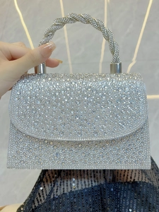 Close-up of sparkling silver evening bag with rhinestones and twisted metal handle