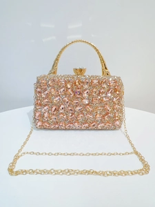 Detail of champagne pink crystals and rhinestones on luxury evening handbag with gold chain