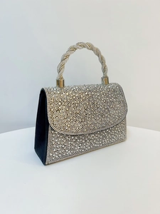 Macro shot of silver rhinestone evening bag showing sparkling crystals and twisted handle