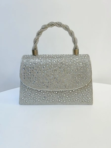 Close-up of sparkling silver rhinestone handbag with twisted diamond-studded handle