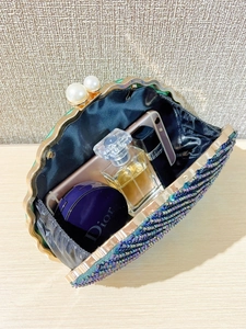 Detail view of green beaded evening bag interior with luxury shell frame and pearl clasp