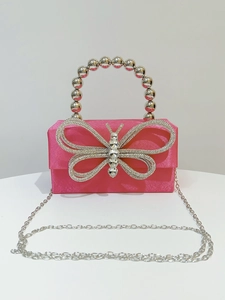 Detail of rose silk evening bag with large crystal butterfly and silver beaded handle