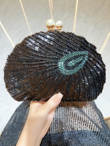 Detailed close-up of handmade black beaded evening clutch with green sequin eye pattern