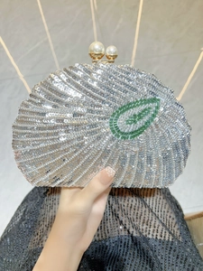 Detail of shell-shaped silver sequin evening bag with pearl clasp and leaf beadwork