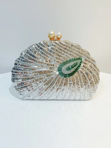 Close-up of silver sequins and white beads with shell patterns and pearl clasp on clutch