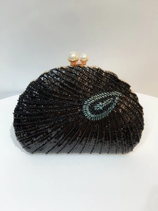 Detail of black beaded clutch with sequins, blue teardrop motif and double pearl clasp