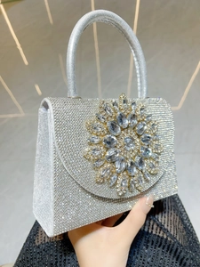 Détail du sac à main argenté avec strass et boucle en cristal en forme de tournesol