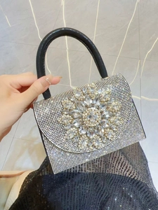 Détail du sac de soirée en strass argentés avec broche en cristal et poignée noire
