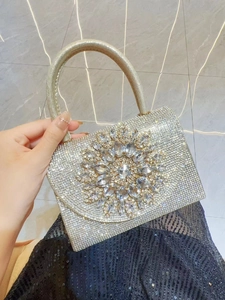 Détail de la pochette de soirée argentée avec strass et ornement floral en cristal