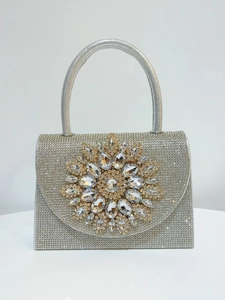 Détail du sac de soirée argenté orné de strass étincelants et d'une fleur en cristal