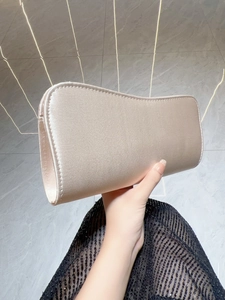 Elegant champagne gold satin clutch bag with curved opening for evening parties