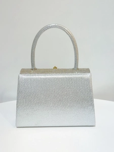 Détail de la pochette de soirée argentée avec bordures en strass et texture scintillante