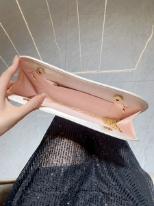White textured evening clutch bag with pink lining and golden chain strap for women