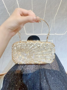 Detail of evening clutch bag with radiating rhinestones and circular gold handle