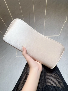 Close-up of pearl white satin evening clutch bag with elegant curved rectangular design