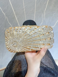 Detailed shot of golden evening clutch bag featuring radiant rhinestone patterns and metal clasp