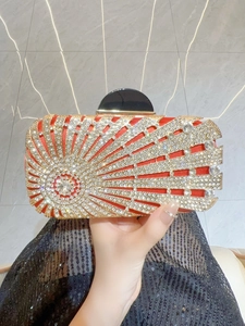 Detail of red satin clutch with crystal sunburst pattern and black gemstone clasp