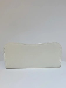 Detail of white suede rectangle clutch featuring precise contrast stitching and premium texture