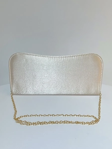 Detail of champagne gold satin clutch bag featuring a sleek fine gold chain strap
