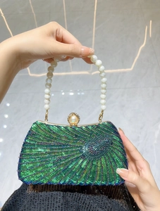 Detailed shot of emerald sequin evening bag with pearl handle and rhinestone clasp