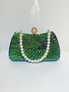 Detail of teal gradient sequins and white faux pearl handle on a luxury evening clutch bag