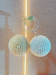 Elegant spherical pearl evening bags in gold and silver with rhinestone ring handles
