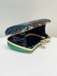 Detailed view of luxury sequin evening bag with green satin and pearl strap handle