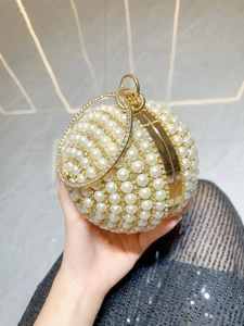 Close-up of spherical evening bag featuring white pearls and rhinestone embellishments