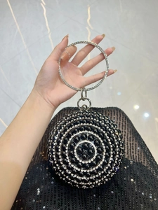 Detail of a round vintage evening bag with black pearls, rhinestones and metal handle