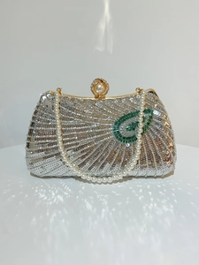 Detail of silver sequin evening clutch with green bead feather and pearl top handle