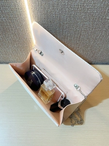 Vue détaillée de l'intérieur d'une pochette crème avec espace pour téléphone et maquillage