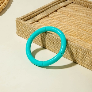 Detail of vibrant teal segment stretch bracelet on linen jewelry tray with natural lighting