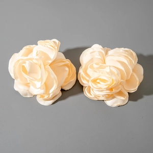 Gros plan détaillé des boucles d'oreilles camélia en tissu blanc crème aux pétales superposés