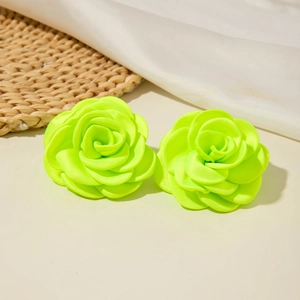 Détail de boucles d'oreilles camélia en tissu vert néon avec pétales en textile doux