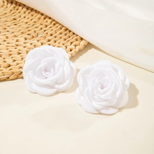 Détail de boucles d'oreilles camélia en tissu blanc avec pétales 3D multicouches