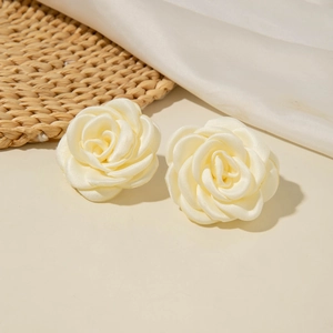 Vue détaillée des boucles d'oreilles camélia en tissu crème aux pétales satinés