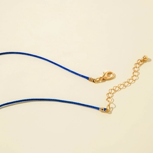 Dettaglio della chiusura a moschettone dorata e catenella di estensione su cordino blu
