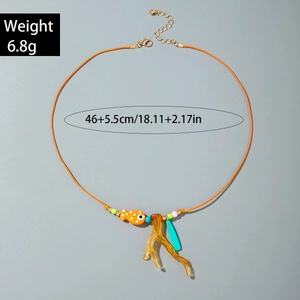 Dettaglio del ciondolo a forma di pesce arancione e corallo su cordino di cera