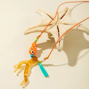Collana tessuta a mano con ciondoli a forma di corallo e pesce su una stella marina