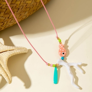 Dettaglio di una collana di perline fatta a mano con pesce rosa e corallo su un cappello