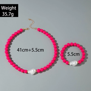 Détail d'un ensemble de bijoux en perles roses avec perle baroque et fermoir doré