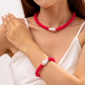 Détail d'un ensemble collier et bracelet en perles rouge rose avec perle baroque sur mannequin