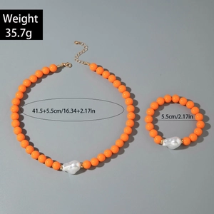 Détail d'un ensemble de bijoux en perles orange avec perle baroque et poids de 35,7g