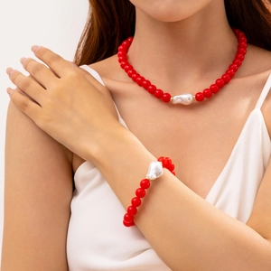 Détail de parure bijoux en perles rouges avec perle baroque sur un mannequin