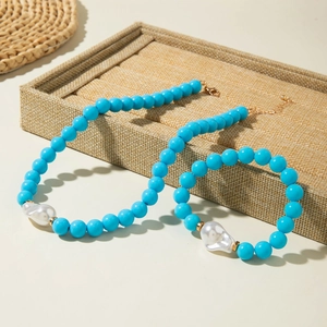 Détail d'un ensemble collier et bracelet en perles bleues avec perle baroque