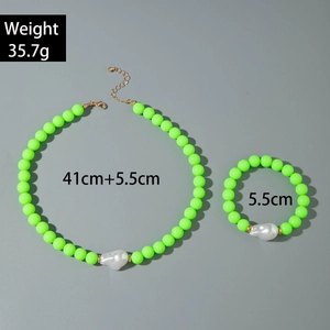 Vue à plat de parure de bijoux perles vert fluo avec perles baroques et or