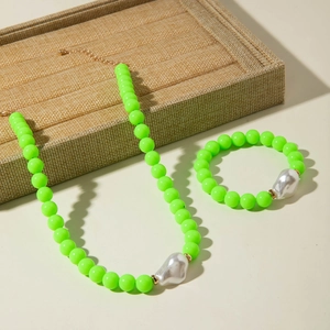 Détail de l'ensemble collier et bracelet en perles vert néon avec perles baroques argent